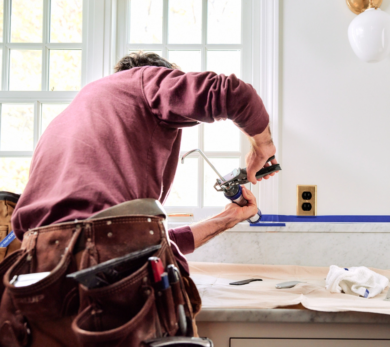 2-applying-ge-supreme-silicone-to-a-countertop-backsplash-seam-with-painters-tape
